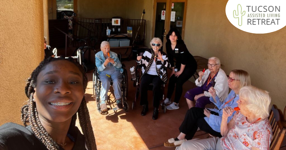 A caregiver takes a selfie with a happy group of seniors enjoy popsicles and another caregiver, highlighting the positive effect senior care careers can have.
