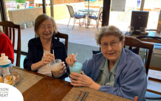 2 senior residents eat and drink together, representing the value of good nutrition as a part of diabetes care.